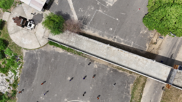 Aerial view of the National Stadium Surulere grounds with people walking on asphalt near a concrete walkway and green trees in Lagos Lagos Nigeria. Aerial view of the National Stadium Surulere grounds with people walking on asphalt near a concrete walkway and green trees in Lagos Lagos Nigeria.