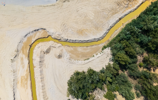 Aerial view of Burnout Lake near Salfold Hungary showing sandy shores reeds and forest surrounding the quarry lake in the Balaton region in summer.