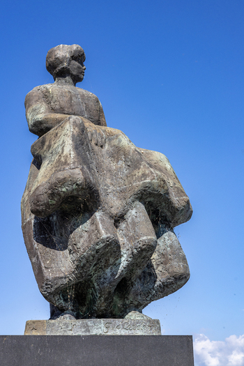 View of the Fisherman s Monument a bronze statue of a woman looking out to sea against a clear blue sky in Urk Flevoland Netherlands. View of the Fisherman s Monument a bronze statue of a woman looking out to sea against a clear blue sky in Urk Flevoland Netherlands.
