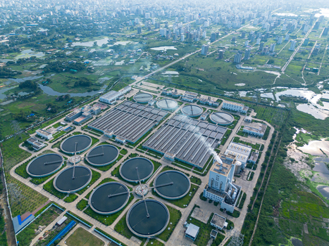 Aerial view of the Sewage Treatment Plant Dhaka WASA featuring circular settling tanks and industrial structures near the city skyline Dhaka Dhaka Division Bangladesh. Aerial view of the Sewage Treatment Plant Dhaka WASA featuring circular settling tanks and industrial structures near the city skyline Dhaka Dhaka Division Bangladesh.
