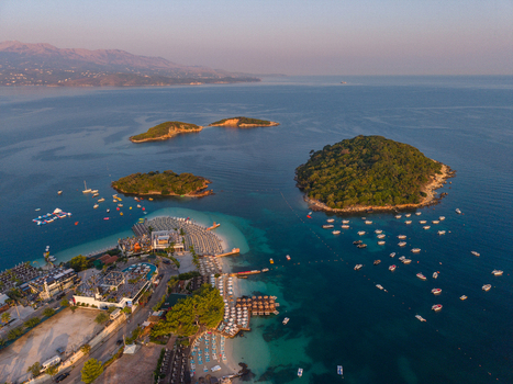 Aerial view of the Ksamil Islands featuring turquoise waters sandy beaches boats anchored in the bay and lush green vegetation at Ksamil Vlore County Albania. Aerial view of the Ksamil Islands featuring turquoise waters sandy beaches boats anchored in the bay and lush green vegetation at Ksamil Vlore County Albania.