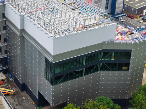 Aerial view of a modern data center under construction with a steel frame roof glass facade and metal cladding in the United Kingdom.