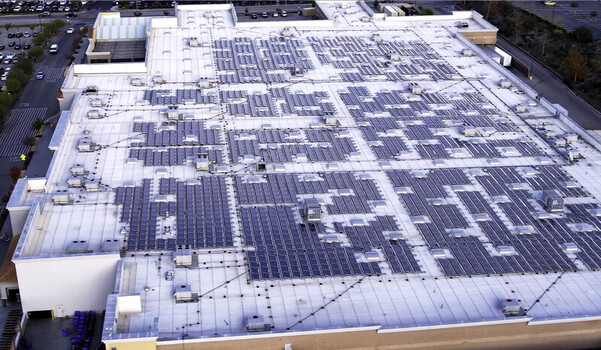 Aerial view of a large solar panel array installed on the flat roof of a commercial building in Los Angeles CA United States. Aerial view of a large solar panel array installed on the flat roof of a commercial building in Los Angeles CA United States.