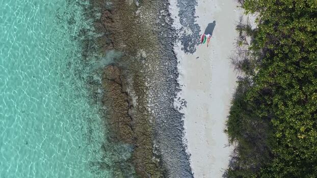 Aerial view of a person walking on a beach in Maldives.