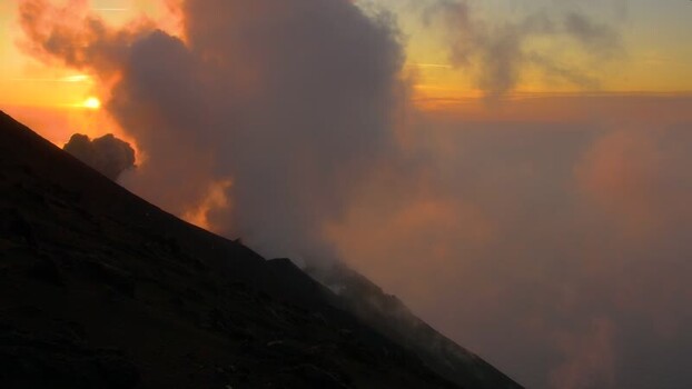 View of Stromboli volcano erupting at sunset Italy.