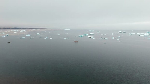 Aerial view of icebergs and a boat near Disko Island Greenland. Aerial view of icebergs and a boat near Disko Island Greenland.