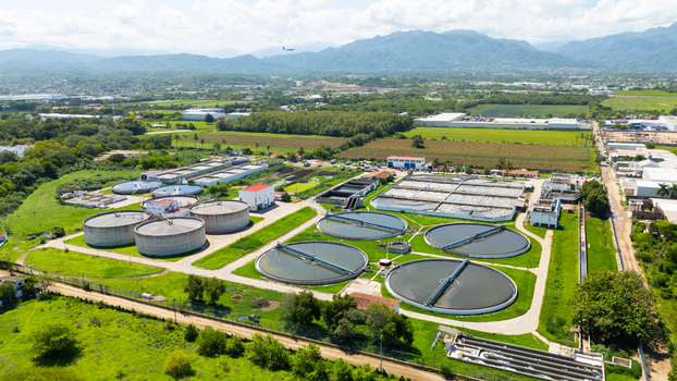Aerial view of circular water treatment tanks contrasting against the surrounding green landscape and distant mountains Puerto Vallarta Mexico. Aerial view of circular water treatment tanks contrasting against the surrounding green landscape and distant mountains Puerto Vallarta Mexico.