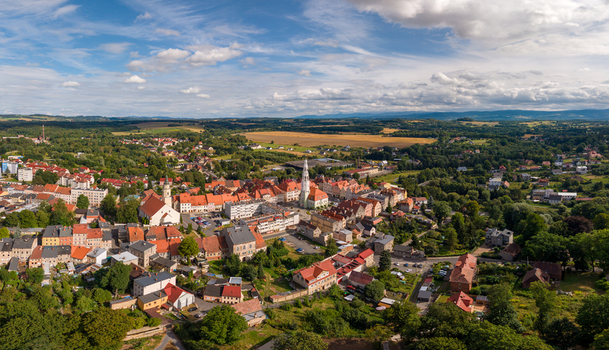 Aerial view of the historic town of Gryfow Slaski with red tiled rooftops a central church spire and green landscapes under a blue sky in Gryfow Slaski Lower Silesia Poland. Aerial view of the historic town of Gryfow Slaski with red tiled rooftops a central church spire and green landscapes under a blue sky in Gryfow Slaski Lower Silesia Poland.