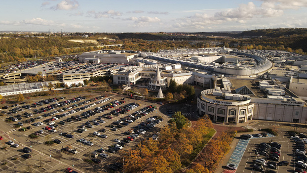 Aerial view of Bluewater Shopping Centre with its extensive parking lots modern architecture and surrounding green landscape in Dartford England United Kingdom. Aerial view of Bluewater Shopping Centre with its extensive parking lots modern architecture and surrounding green landscape in Dartford England United Kingdom.