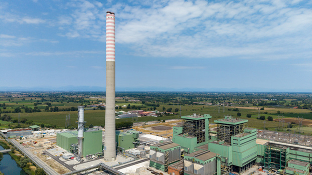Aerial view of the Tavazzano power station a combined cycle natural gas plant with a tall striped chimney and industrial buildings in Tavazzano con Villavesco Lombardy Italy.