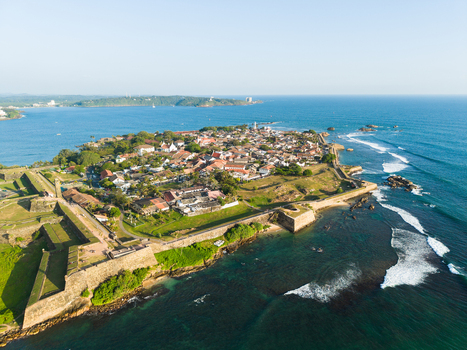 Aerial view of the historic Galle Fort with its massive stone ramparts colonial architecture and turquoise ocean waves under a clear sky Galle Southern Province Sri Lanka.