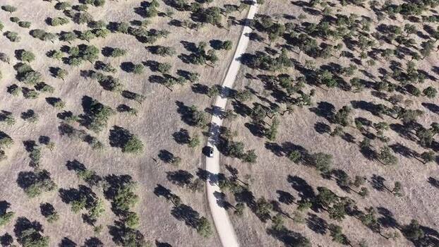 Aerial view of a car on a dirt road in Valencia de Alcantara Spain.