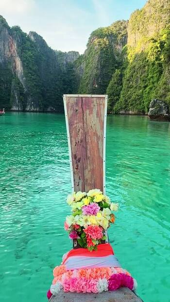 View of decorated boat prow on turquoise water Thailand.