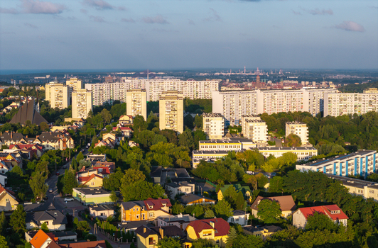Aerial view of residential apartment blocks and houses surrounded by lush green trees and a church in Gdansk Pomeranian Voivodeship Poland. Aerial view of residential apartment blocks and houses surrounded by lush green trees and a church in Gdansk Pomeranian Voivodeship Poland.