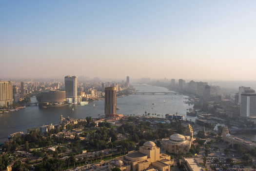 Cairo Egypt 19 October 2025 View of the tranquil Nile River winding through the hazy cityscape with the iconic Cairo Tower and the modern cylindrical building standing tall against the pale sky. Cairo Egypt 19 October 2025 View of the tranquil Nile River winding through the hazy cityscape with the iconic Cairo Tower and the modern cylindrical building standing tall against the pale sky.