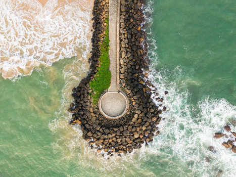 Aerial view of the circular stone pier at View Point Mahamodara fishing spot with turquoise waves crashing against the rocks and sandy beach in Galle Sri Lanka. Aerial view of the circular stone pier at View Point Mahamodara fishing spot with turquoise waves crashing against the rocks and sandy beach in Galle Sri Lanka.