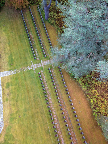 Aerial view of the military cemetery with rows of headstones set in green lawns and stone paths surrounded by pine trees in Muhos North Ostrobothnia Finland. Aerial view of the military cemetery with rows of headstones set in green lawns and stone paths surrounded by pine trees in Muhos North Ostrobothnia Finland.