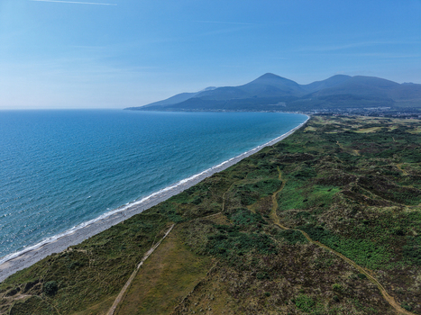 Aerial view of the Mourne Mountains rising above the coastline and sandy beach near Newcastle Northern Ireland United Kingdom. Aerial view of the Mourne Mountains rising above the coastline and sandy beach near Newcastle Northern Ireland United Kingdom.