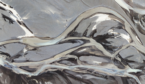 Aerial view of a complex braided river system with glacial meltwater channels flowing through dark volcanic sand in Iceland. Aerial view of a complex braided river system with glacial meltwater channels flowing through dark volcanic sand in Iceland.