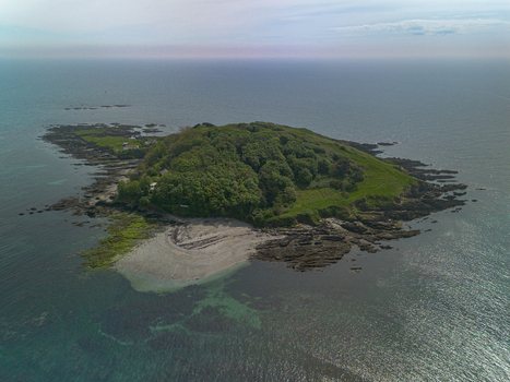 Aerial view of Looe Island surrounded by rocky coastline and clear blue sea in Looe Cornwall United Kingdom. Aerial view of Looe Island surrounded by rocky coastline and clear blue sea in Looe Cornwall United Kingdom.