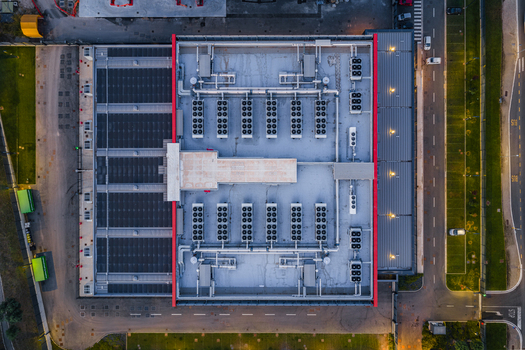 Aerial view of a modern datacenter roof featuring rows of HVAC cooling units ventilation pipes and industrial infrastructure located in Settecamini Lazio Italy.