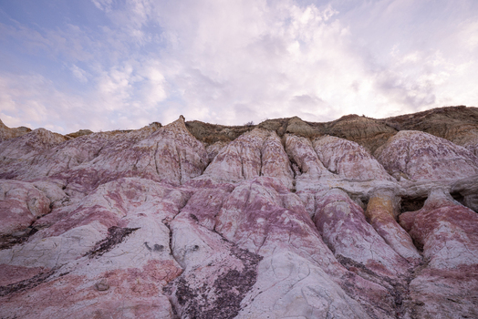 View of the colorful clay formations and pink rock layers at Paint Mines Interpretive Park under a cloudy sky in Calhan Colorado United States.