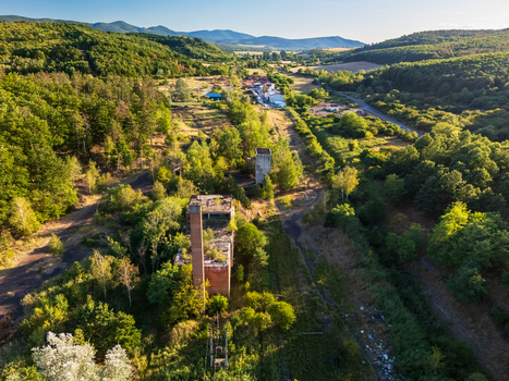 Aerial view of abandoned coal loading structures in a forested valley near Rakoczibanya Hungary with the Matra Mountains and surrounding hills in summer. Aerial view of abandoned coal loading structures in a forested valley near Rakoczibanya Hungary with the Matra Mountains and surrounding hills in summer.