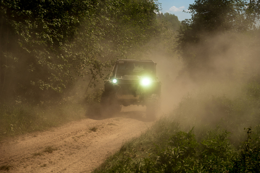View of an off road vehicle driving through a dusty forest path near Lake Ladoga in Sortavala Respublika Kareliya Russia.