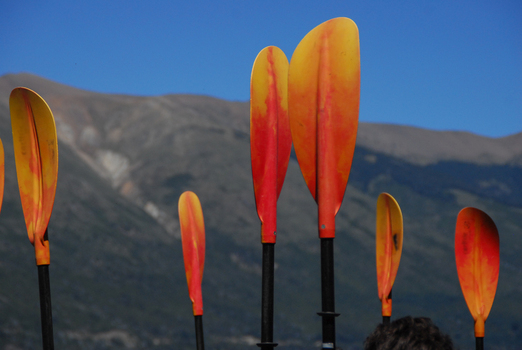 View of orange and yellow kayak paddles standing upright with the mountains and Nahuel Huapi Lake in the background SAN CARLOS DE BARILOCHE Rio Negro Argentina. View of orange and yellow kayak paddles standing upright with the mountains and Nahuel Huapi Lake in the background SAN CARLOS DE BARILOCHE Rio Negro Argentina.