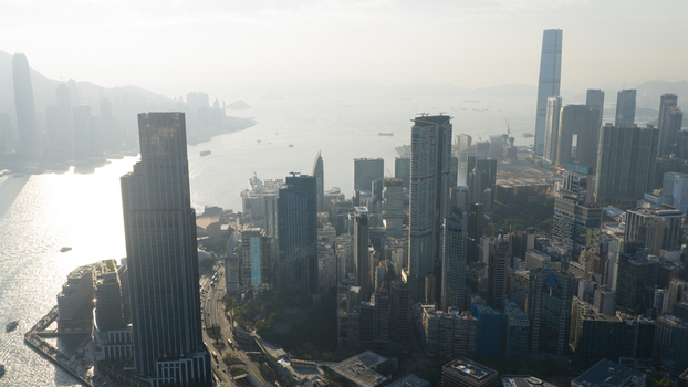 Aerial view of modern skyscrapers and Victoria Harbour under a hazy morning sky in Hong Kong Hong Kong. Aerial view of modern skyscrapers and Victoria Harbour under a hazy morning sky in Hong Kong Hong Kong.