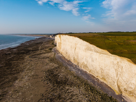 Aerial view of the dramatic white chalk cliffs at the Beach of the Bois de Cise meeting the sea and sandy coastline in Ault Hauts de France France.