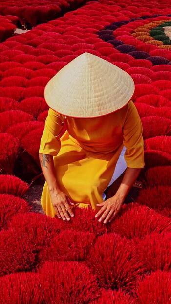 View of a person working with red incense sticks Vietnam.