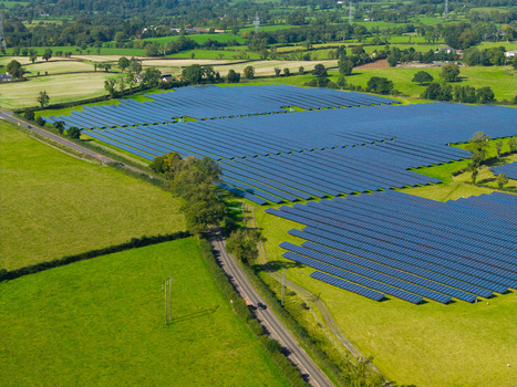 Aerial view of a large solar farm with rows of photovoltaic panels set in green rural fields near a road in Lisburn Northern Ireland United Kingdom. Aerial view of a large solar farm with rows of photovoltaic panels set in green rural fields near a road in Lisburn Northern Ireland United Kingdom.