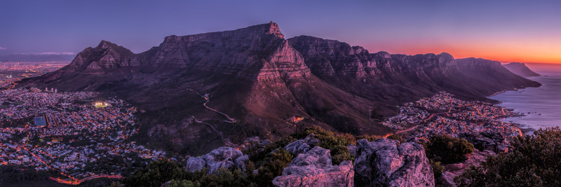 View of Table Mountain at sunset with the city lights of Cape Town glowing below in South Africa.