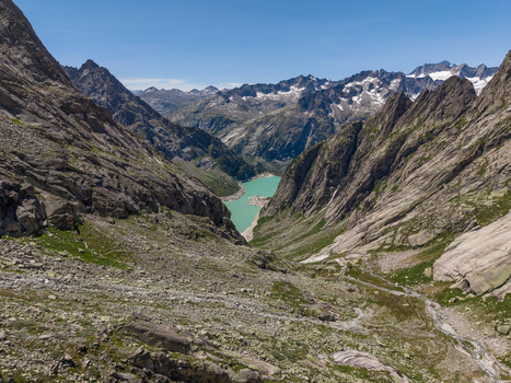 Aerial view of Gelmersee an alpine reservoir nestled among rugged rocky mountains and steep slopes in Switzerland.