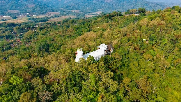 Aerial view of Bukit Rhema Gereja Ayam nestled in the lush green forest of the hills in Kecamatan Borobudur Jawa Tengah Indonesia.