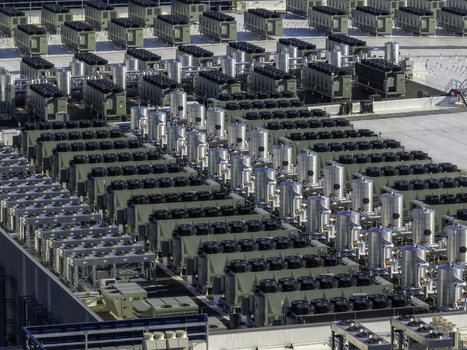 Aerial view of a large industrial rooftop covered with rows of HVAC cooling units and ventilation systems in Elk Grove Village Illinois United States.
