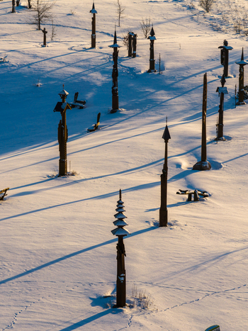 Aerial view of the Hill of Angels featuring tall wooden sculptures casting long shadows over a pristine snow covered landscape during winter Traku rajonas Vilniaus apskritis Lithuania. Aerial view of the Hill of Angels featuring tall wooden sculptures casting long shadows over a pristine snow covered landscape during winter Traku rajonas Vilniaus apskritis Lithuania.