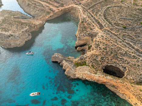 Aerial view of azure waters contrasting with the rugged sun baked cliffs of the Blue Lagoon a tranquil escape Blue lagoon Comino Malta. Aerial view of azure waters contrasting with the rugged sun baked cliffs of the Blue Lagoon a tranquil escape Blue lagoon Comino Malta.