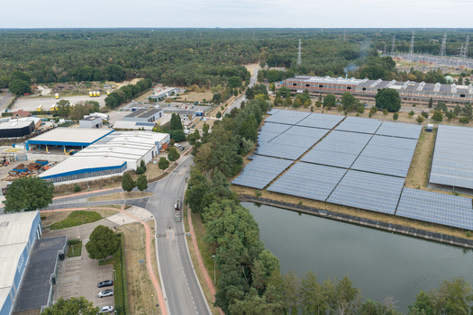 Aerial view of the Haven Genk solar power plant featuring extensive photovoltaic panels industrial infrastructure and a nearby waterway in Genk Vlaanderen Belgium.