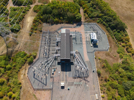 Aerial view of Eaton Socon Substation featuring high voltage electrical infrastructure and transformers within a fenced compound surrounded by trees in St. Neots England United Kingdom. Aerial view of Eaton Socon Substation featuring high voltage electrical infrastructure and transformers within a fenced compound surrounded by trees in St. Neots England United Kingdom.