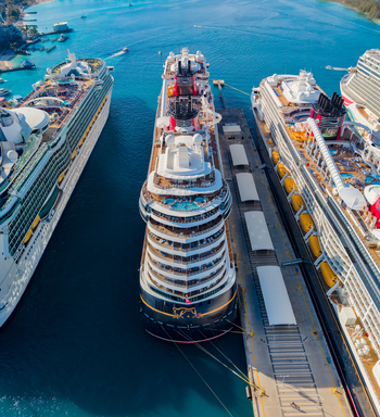 Aerial view of Nassau Cruise Port with multiple large cruise ships docked at the pier surrounded by turquoise Caribbean waters in Nassau The Bahamas. Aerial view of Nassau Cruise Port with multiple large cruise ships docked at the pier surrounded by turquoise Caribbean waters in Nassau The Bahamas.