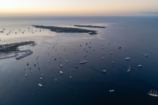 Aerial view of the Mediterranean Sea near Cannes featuring numerous yachts and sailboats anchored near the Lerins Islands during a calm sunset in Cannes Provence Alpes Cote d Azur France. Aerial view of the Mediterranean Sea near Cannes featuring numerous yachts and sailboats anchored near the Lerins Islands during a calm sunset in Cannes Provence Alpes Cote d Azur France.