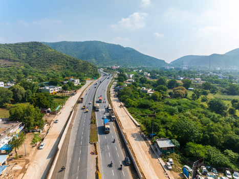 Aerial view of a multi lane highway winding through lush green hills and rural landscapes in Udaipur Rajasthan India. Aerial view of a multi lane highway winding through lush green hills and rural landscapes in Udaipur Rajasthan India.