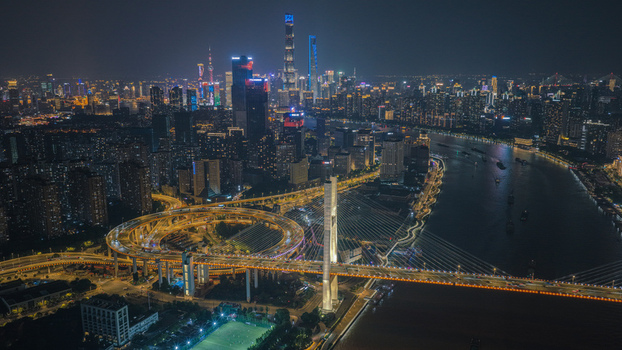 Aerial view of the illuminated Nanpu Bridge with its spiral ramp and the glowing city skyline at night in Shanghai Shanghai China. Aerial view of the illuminated Nanpu Bridge with its spiral ramp and the glowing city skyline at night in Shanghai Shanghai China.
