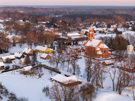 Aerial view of the red brick Church of Our Lady of the Scapular and snow covered houses in the historic village of Kernave Vilnius County Lithuania.
