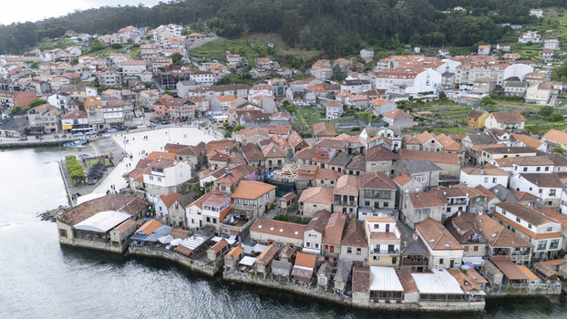Combarro Spain 02 May 2026 Aerial view of Horreos de Combarro traditional stone granaries along the waterfront with people walking in the village square and red tiled roofs.