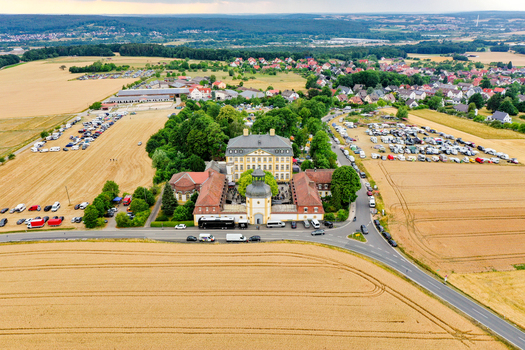 Eggolsheim Germany 09 May 2026 Aerial view of Schloss Jagersburg with its yellow facade surrounded by golden fields and parking areas under a cloudy sky. Eggolsheim Germany 09 May 2026 Aerial view of Schloss Jagersburg with its yellow facade surrounded by golden fields and parking areas under a cloudy sky.