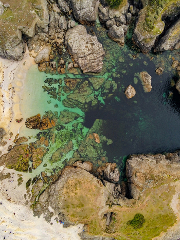 Aerial view of the rugged coastline of Ile de Groix featuring turquoise waters rocky cliffs and sandy beach areas in Groix Bretagne France. Aerial view of the rugged coastline of Ile de Groix featuring turquoise waters rocky cliffs and sandy beach areas in Groix Bretagne France.