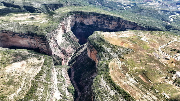 Aerial view of El Vergel canyon with deep gorge steep rock walls and a winding river below surrounded by rugged agricultural landscapes in Torotoro Potosi Department Bolivia. Aerial view of El Vergel canyon with deep gorge steep rock walls and a winding river below surrounded by rugged agricultural landscapes in Torotoro Potosi Department Bolivia.